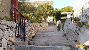 Eine Treppe aus Stein führt zu einem Gebäude mit einem Metallgitter und einer Mauer an der Seite.