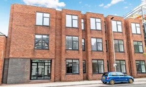 Stylish multi-story building with residential units, featuring clean lines and a well-maintained facade.