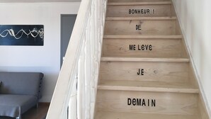 Eine Treppe mit Holzhinweisstufen und einer Handlauf. Auf den Stufen ist Text auf Französisch zu sehen, der übersetzt mit 'Guten Morgen, ich liebe dich, morgen' bedeutet.