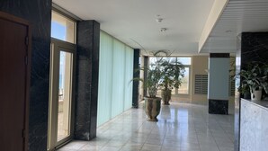 A spacious hallway with marble flooring, large potted plants, and a view of the outdoors through a glass door. - MAGNIFICENT OCEAN VIEW BIARRITZ (Biarritz)