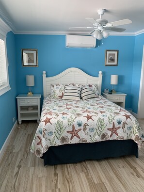 A bedroom with a bed, nightstands, a ceiling fan, and a window. - FALL Getaway, Fishermen, Couples, Families, Pool, Cabana Club (Key Colony Beach)