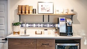 A kitchenette with a coffee machine, microwave, and storage drawers. - Stonewall Motor Lodge (Stonewall)