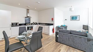 A modern apartment with a kitchen, dining area, and living room. - City Suites by Guestz (Chester)