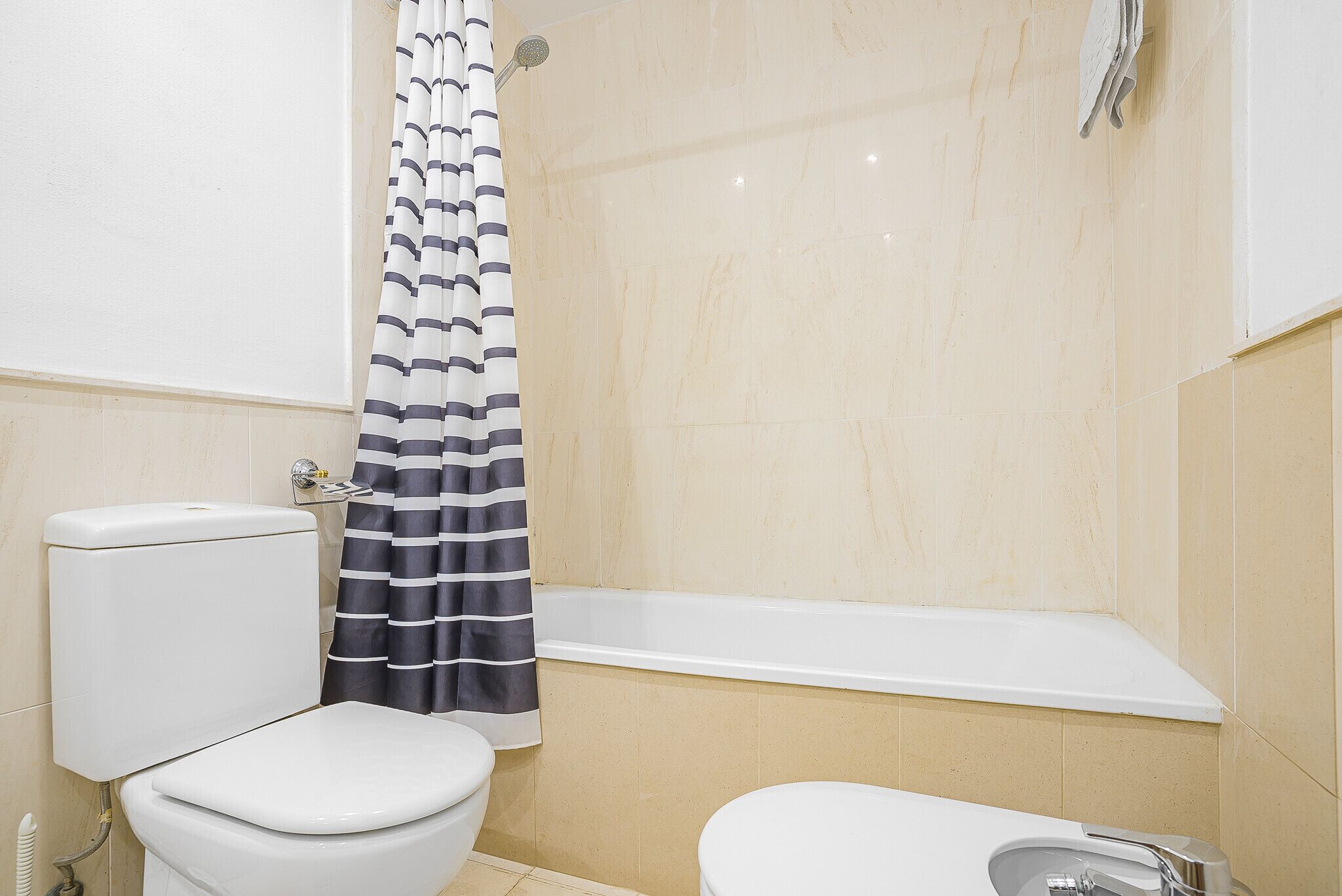 Un baño con inodoro, bañera y cortina de ducha.