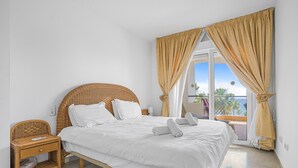 Ein Schlafzimmer mit einem Bett, einem Nachttisch und einem Fenster mit Vorhängen.
