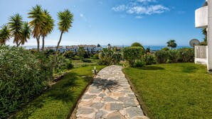 A stone pathway leading to a building with a view of the ocean. - I02 El Alarife - Apartment with sea views (Sitio de Calahonda)