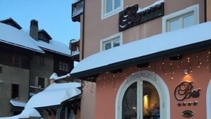 A hotel entrance with a snow-covered roof and steps leading up to the door. - Hotel Bes & Spa (Claviere)