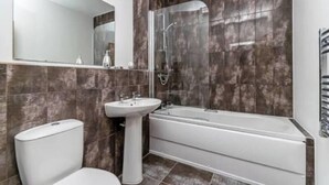 A bathroom with a toilet, pedestal sink, and a bathtub. - Overnight Stay Chester With Parking (Chester)