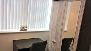A room with a desk, a wardrobe, and a window with blinds. - Overnight Stay Chester With Parking (Chester)