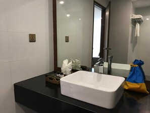 A modern bathroom with a large white sink, a mirror, and a shower area. - Capital Hotel (Mandalay)