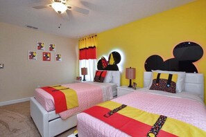 A bedroom with two beds, a ceiling fan, and a yellow wall. - Private Pool & Spa | Private Backyard | BBQ Included | Game Room | 5BR Near Disney (Kissimmee)