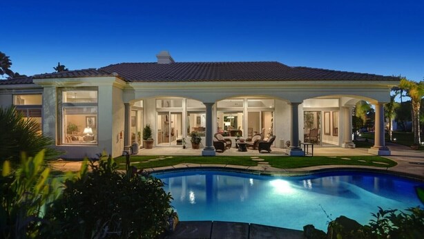 Une grande maison dotée d’une piscine, d’un patio couvert et de plusieurs entrées.