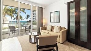 A hotel room with a balcony, a sofa, a table, and a wardrobe.