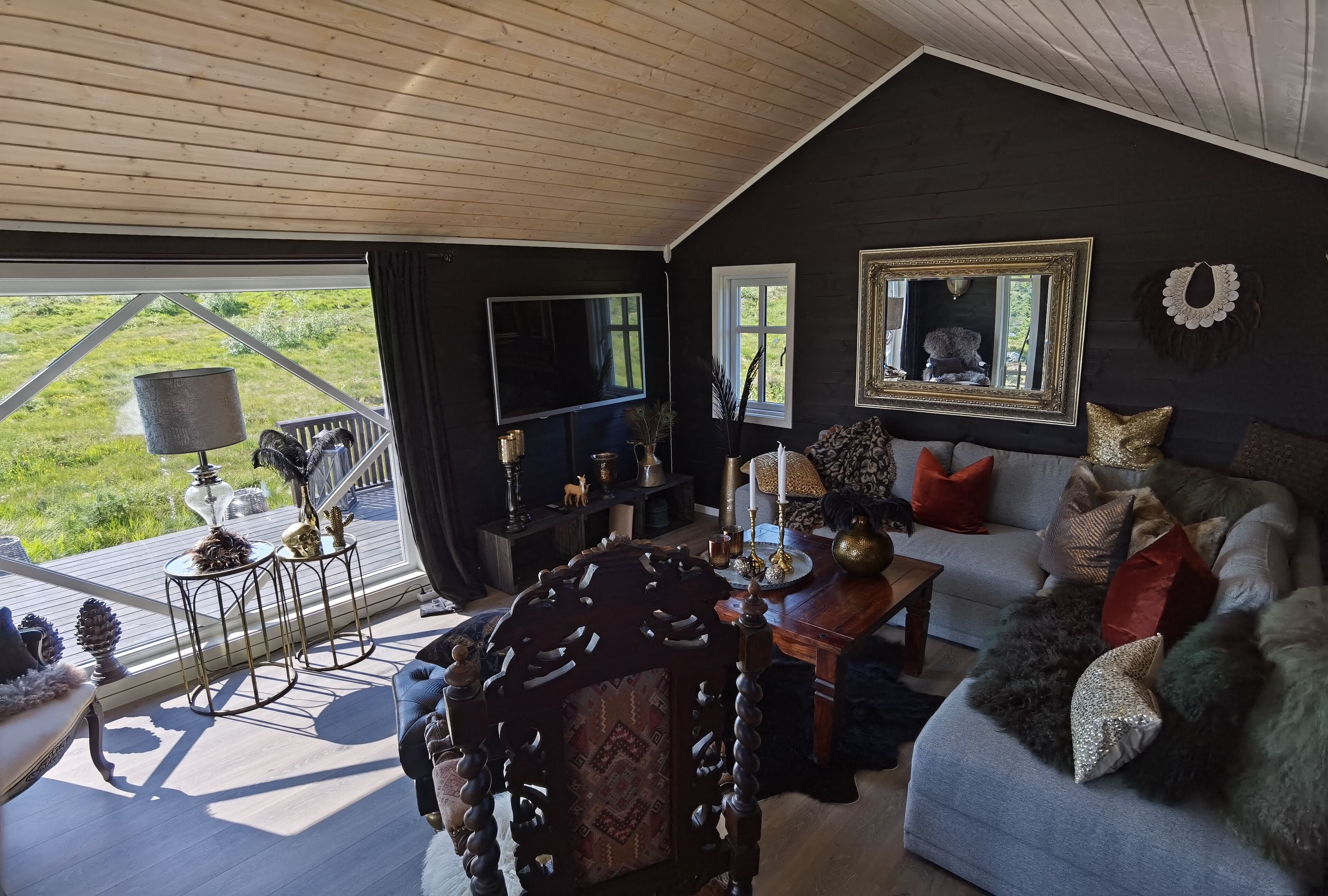 A cozy living room with a large window, a television, and a fireplace.