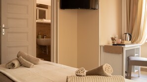 A hotel room with a bed, a television, a desk with a kettle, and a bathroom visible through an open door. - Piazza del Popolo, Vatican City, room, air conditioning, private bathroom, wifi (Roma)