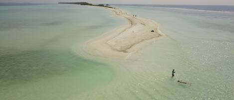 A beach with clear turquoise water and a sandy shoreline.