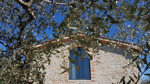 Ein Steinhaus mit einem Fenster und einer weißen Markise.