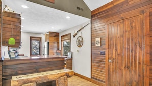 A wooden interior with a reception desk, a bench, a door, and wall-mounted decor.