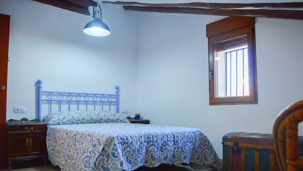 Une chambre à coucher avec un lit, une commode en bois et une fenêtre.