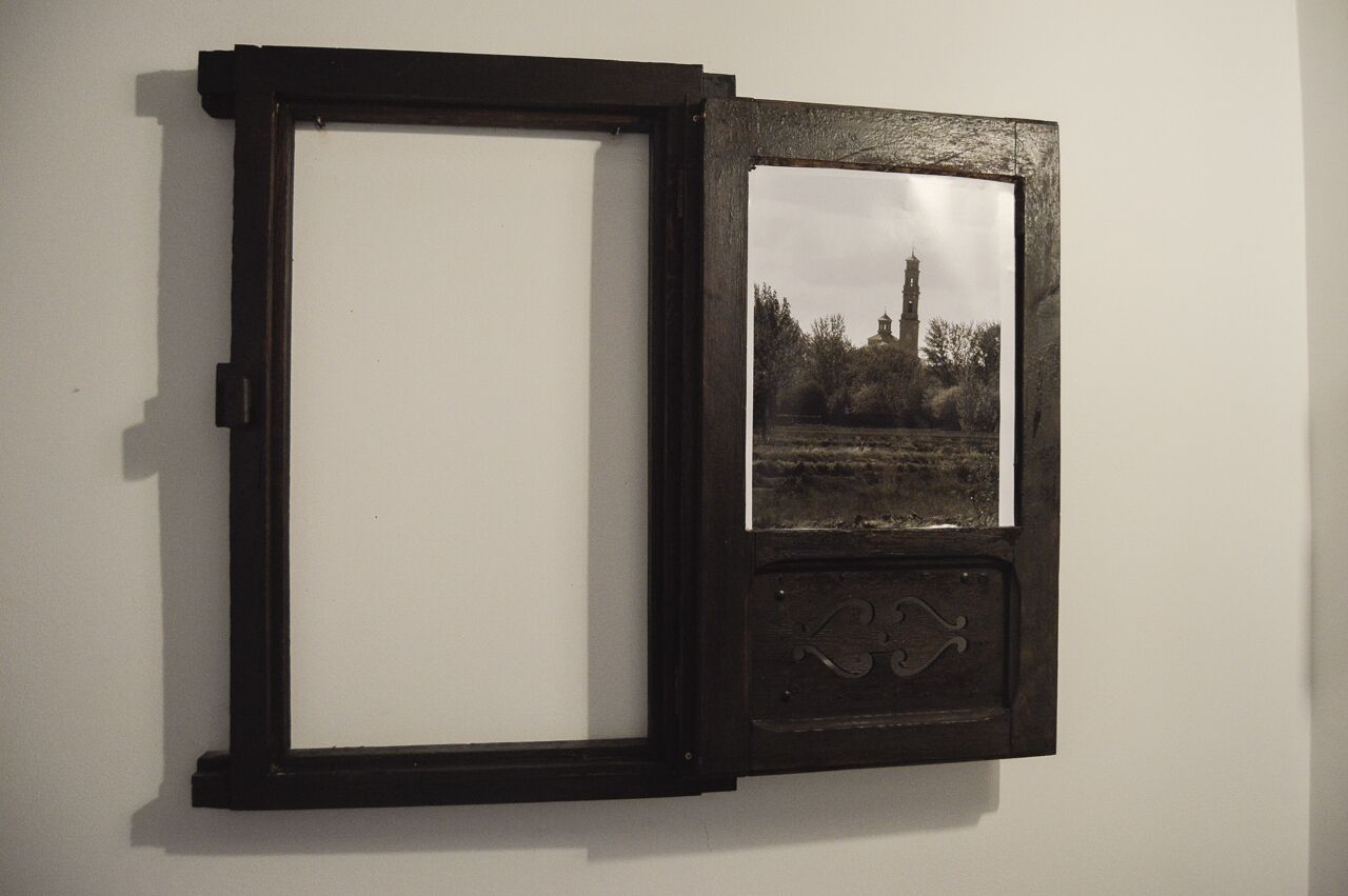 A wall-mounted picture frame with a landscape photo.