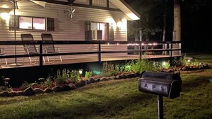 A cabin with a deck, outdoor seating, and a mailbox labeled "APS". - Beautiful Cottage Just minutes from The Twin Lakes & Beach  (Lewiston)