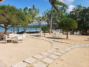 A beachside area with outdoor seating and a paved walkway.