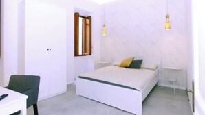 Una camera da letto con un letto, comodini, una sedia e una scrivania.