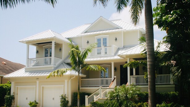A two-story house with a front porch, a garage, and a well-maintained lawn. - 8M Dollar Home, 3 Houses from Beach in Old Naples! (Naples)