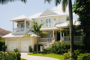 A two-story house with a front porch, a garage, and a well-maintained lawn. - 8M Dollar Home, 3 Houses from Beach in Old Naples! (Naples)