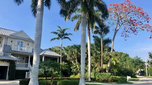 A residential area with a two-story house featuring a covered porch and a garage. - 8M Dollar Home, 3 Houses from Beach in Old Naples! (Naples)