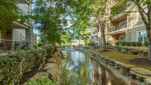 Stroll through the tranquil courtyard, surrounded by lush greenery and two-story buildings with balconies.