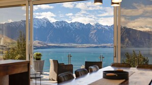 Un espace repas offrant une vue sur un lac et des montagnes.