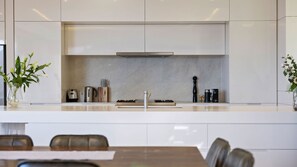 A modern kitchen with a central island, stainless steel appliances, and a minimalist design.