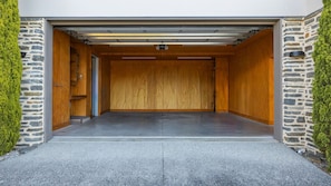 Un garage avec une porte en bois, des murs en pierre et un sol en béton.