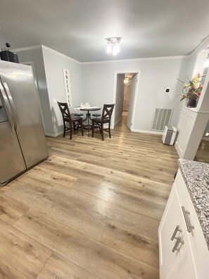 Compact kitchen with central island dining area, featuring a refrigerator, oven, and natural light.