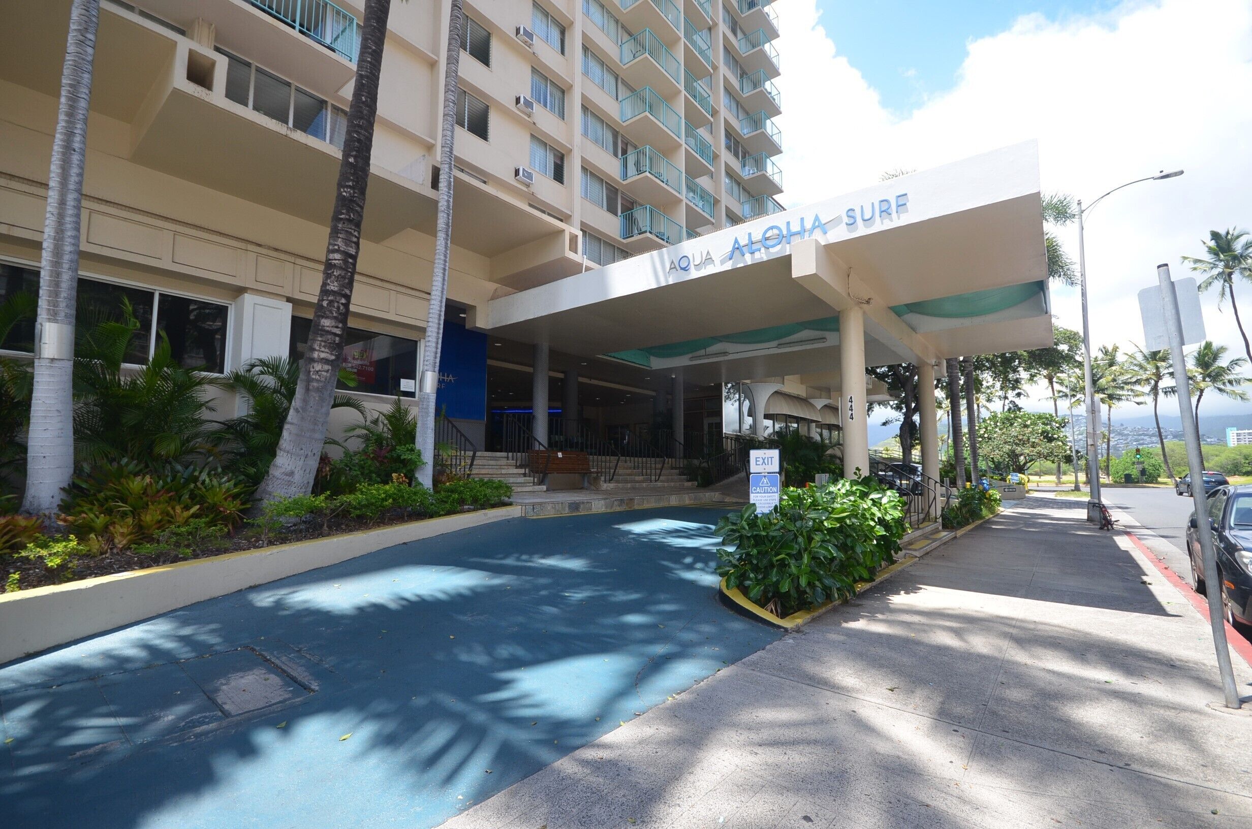 A hotel entrance with a sign reading "AQUA ALOHA SURF".