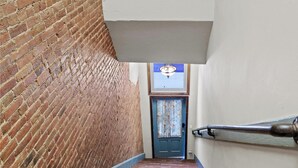 A narrow stairway with wooden steps leading to a door with a blue curtain. - Crossroads Flat:  Steps away from Rt. 66 & Carthage square (Carthage)