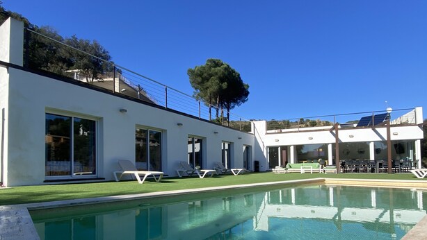 A modern building with a swimming pool, large windows, and outdoor seating. - Casa Rio de Oro with pool featuring beach area and barbecue. Calonge Costa Brava (Calonge)