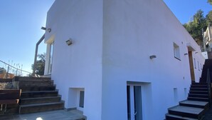 A modern building with a white exterior, a set of wooden stairs leading to a door, and a small window on the side. - Casa Rio de Oro with pool featuring beach area and barbecue. Calonge Costa Brava (Calonge)