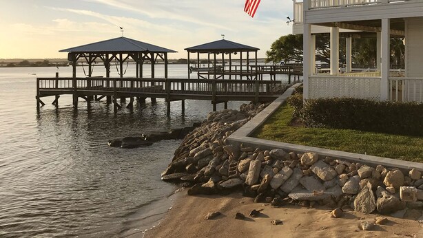 A waterfront property with a dock, a gazebo, and a building with a balcony. - Beach & Boating & Fishing Paradise! With 2 Kayaks Included!!! (St. Augustine)