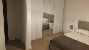 Un dormitorio con cama, mesita de noche y armario.