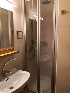 Een douche, een haardroger, een bidet, handdoeken