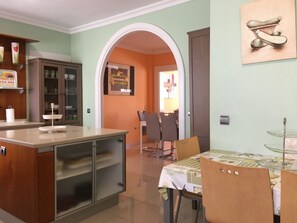 Una cocina con comedor, que incluye una mesa con sillas, un armario y una encimera.