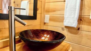 A wooden interior with a modern bathroom sink, a mirror, and a towel rack.