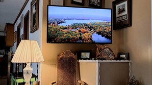 Un televisor instalado en la pared muestra un paisaje pintoresco.