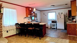 Una cocina compacta con comedor, microondas y refrigerador.