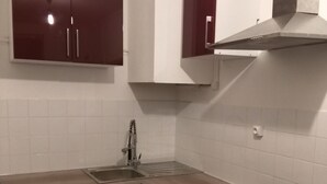 A compact kitchen with a washing machine, a sink, and a stove. - Comfortable & affordable Parisian studio near the metro. (Ivry-sur-Seine)