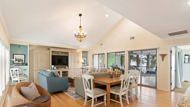 A spacious living area with a dining table, chairs, a sofa, and a chandelier. - Direct Ocean Front, Private Pool, 100 steps to Lighthouse (St Simons Island)