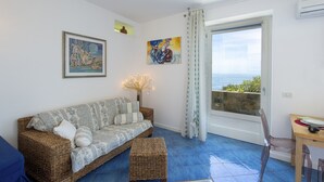 Una sala de estar con un sofá, una mesita y vistas por una ventana.