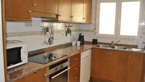 A kitchen with wooden cabinets, a microwave, a coffee maker, and a sink. - aldeamar, bungalow - 2 bedrooms in quiet urbanization. (Els Poblets)